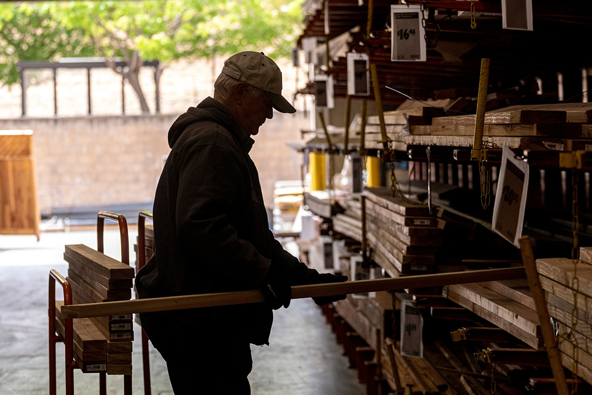 Photo: A customer loads 2x4 wood boards onto a cart inside a Home Depot store in Livermore, California, on May 12, 2022.