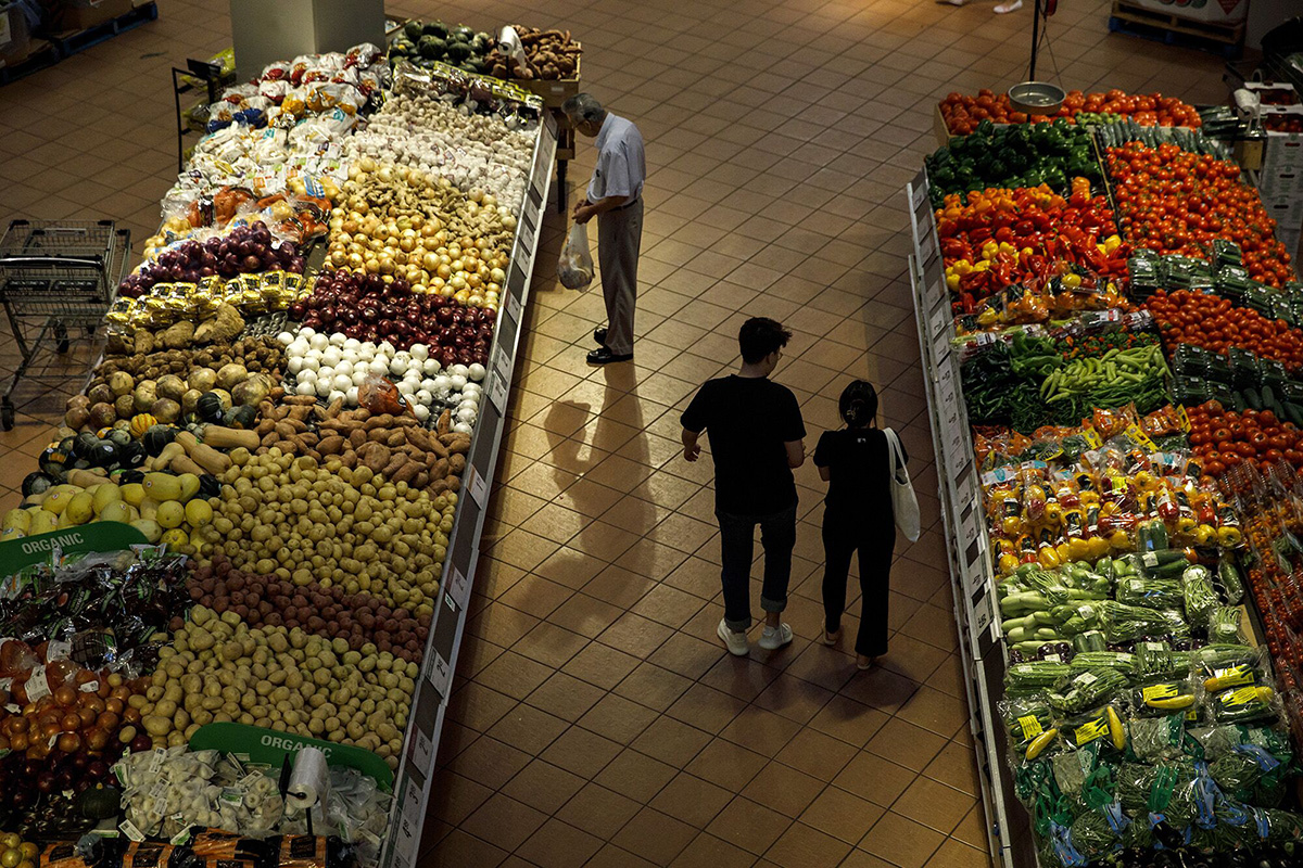 Photo: Shoppers select produce at a grocery store. Photographer: Cole Burston/Bloomberg