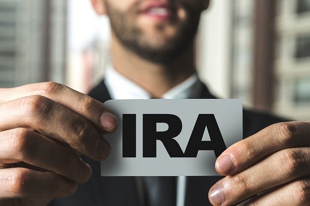 Stock photo: Man holding card with "IRA" on it. (Photo: Shutterstock)