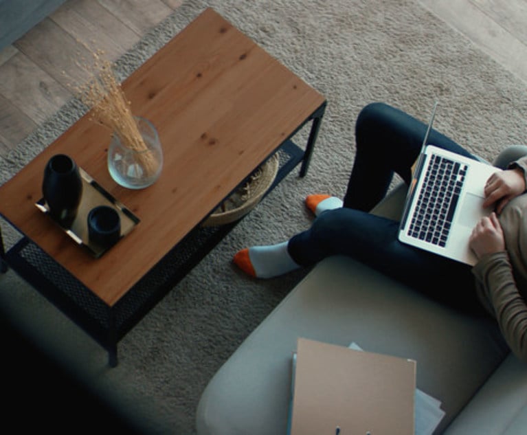 Stock photo of person working from a sofa. Credit: daniilvolkov/Adobe Stock