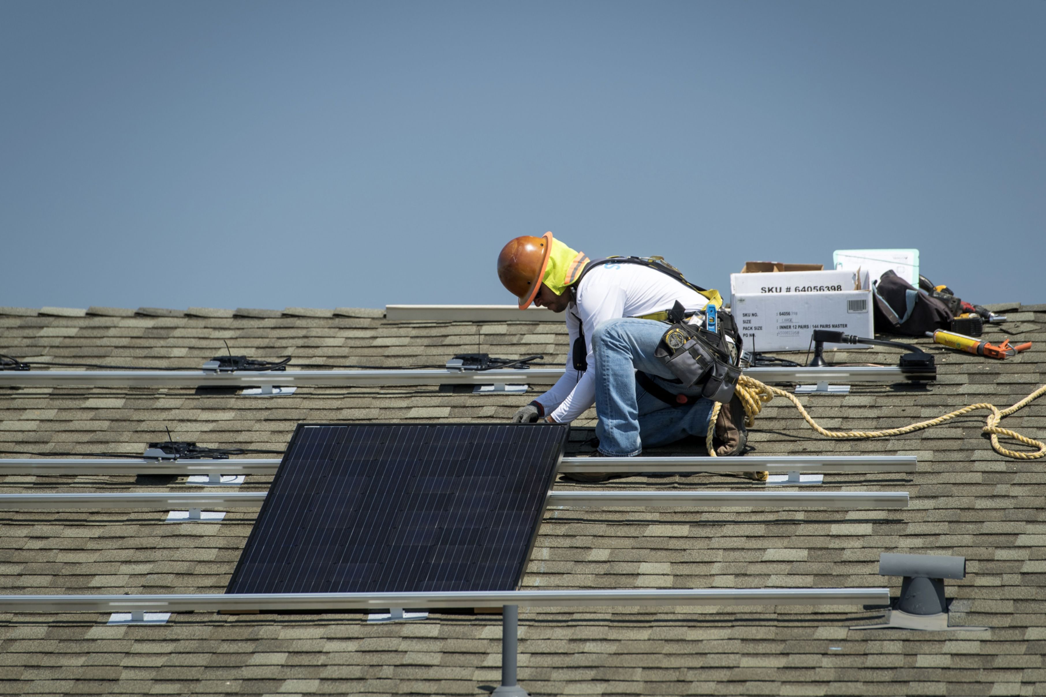 A contractor installs a solar panel on the roof of a new home in Sacramento, California.