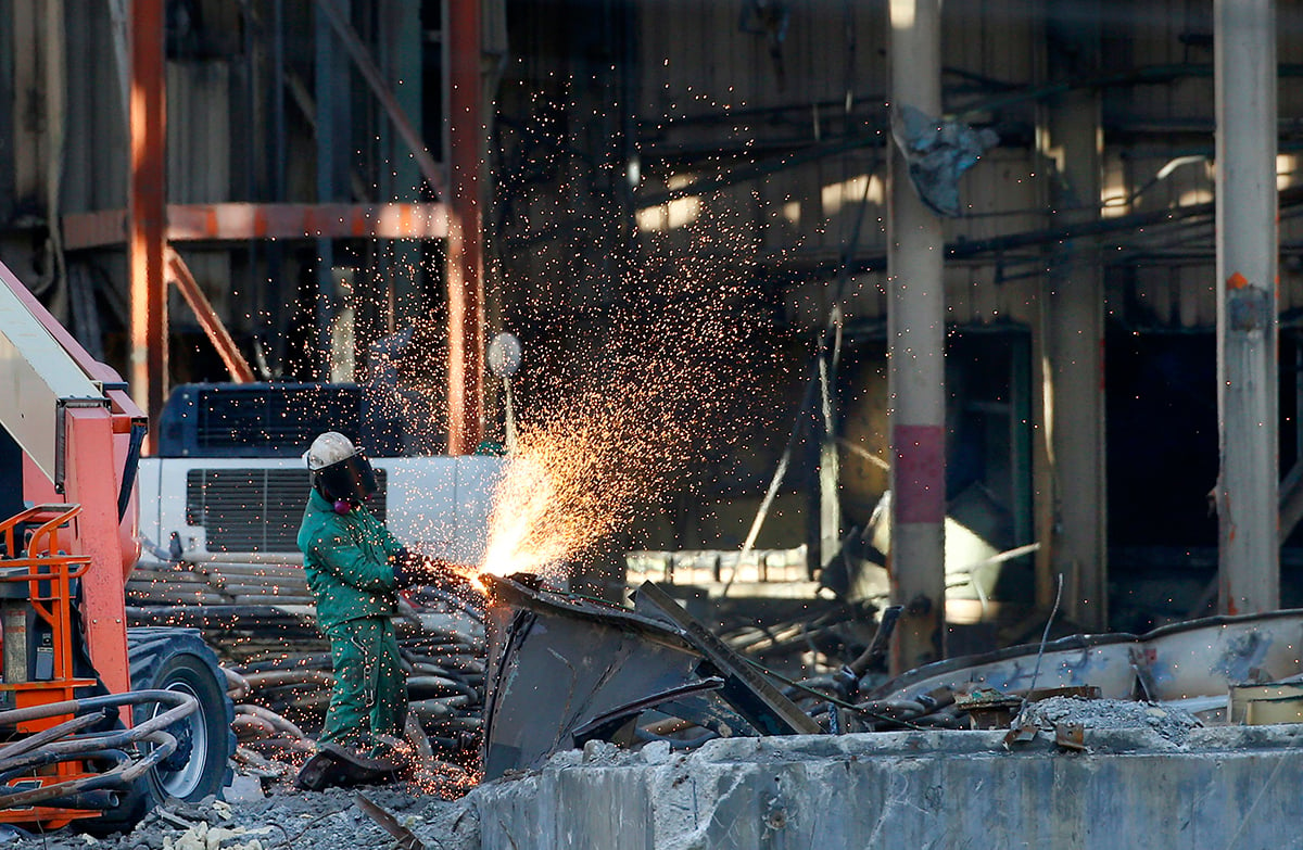 Photo: A worker at a factory. Photographer: George Frey/Bloomberg.