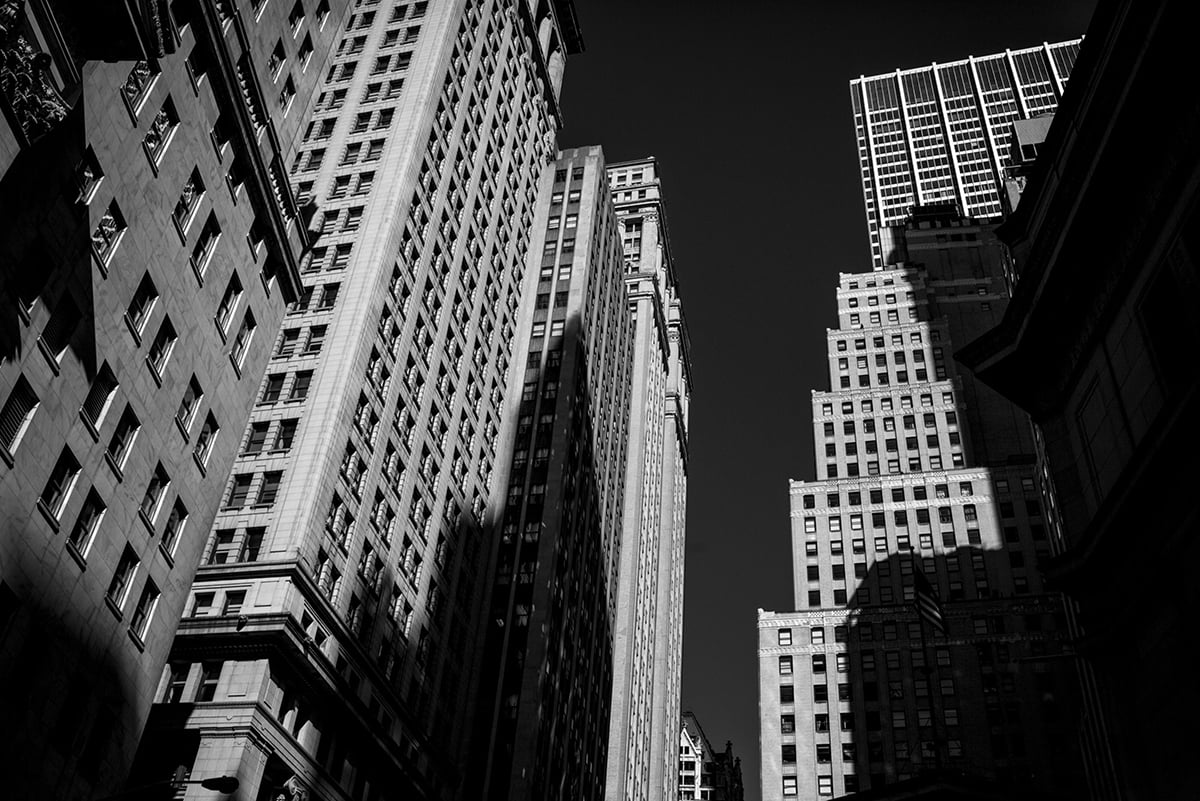 Photo: Buildings on Wall Street near the New York Stock Exchange in New York City. Photographer: John Taggart/Bloomberg.