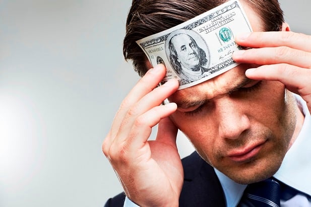 Stock image: man with money pressed to his forehead. (Photo: Getty)