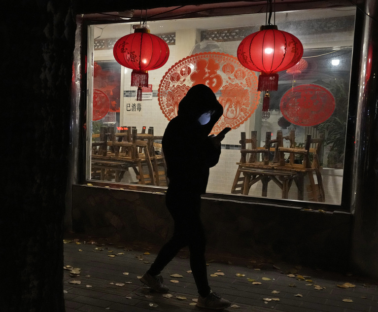 Photo: A woman wearing a mask walks past a restaurant closed to dine-in customers in Beijing on Tuesday. (Photo: Ng Han Guan/AP)