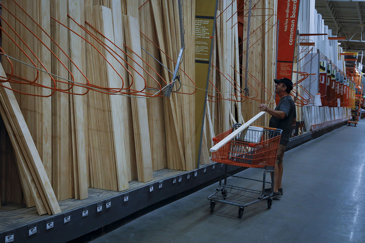 Photo: A customer holds a wood plank at a Home Depot store ahead of Hurricane Ian in Tampa, Florida, on September 27, 2022. 