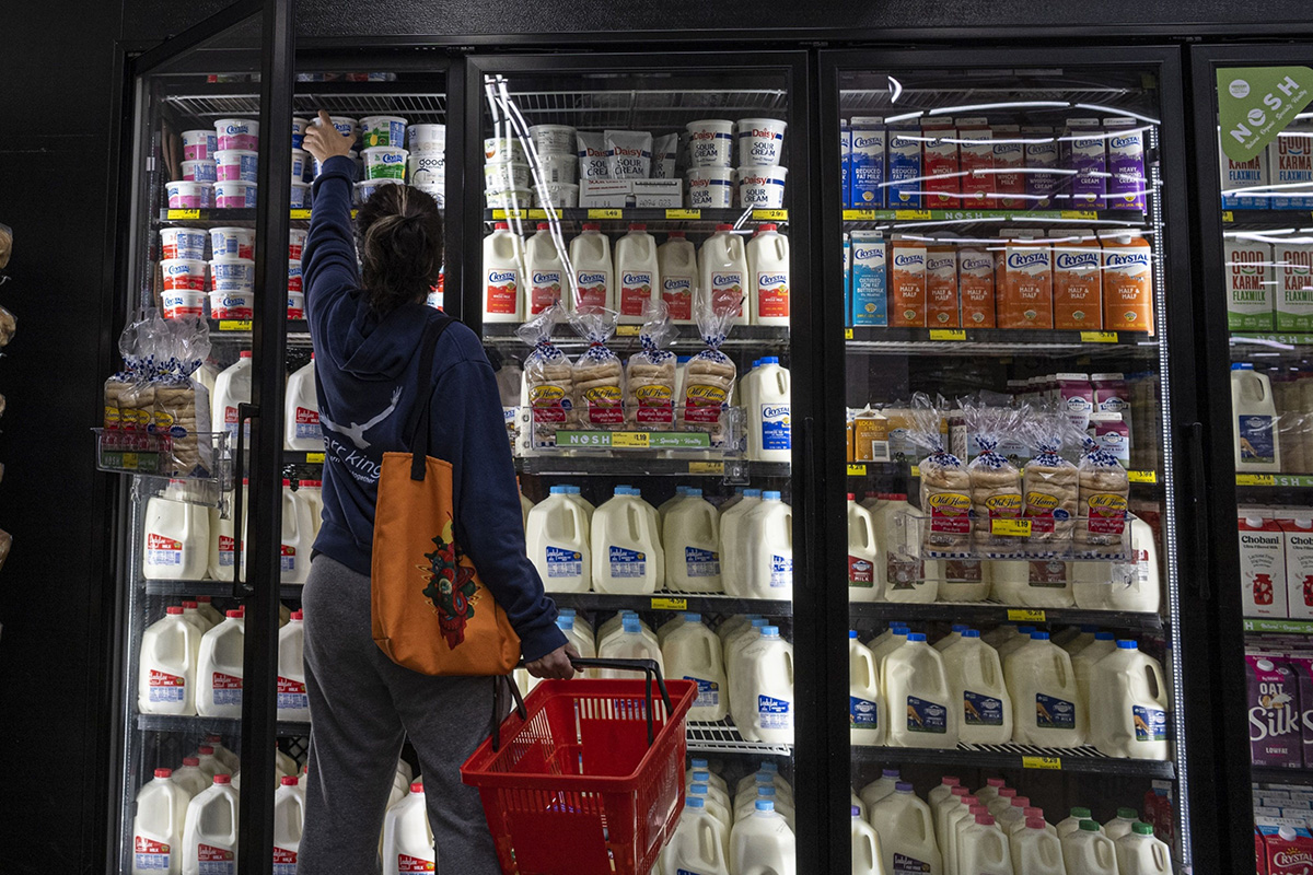 Photo: A shopper reaches for cottage cheese inside a grocery store in San Francisco on May 2, 2022. 