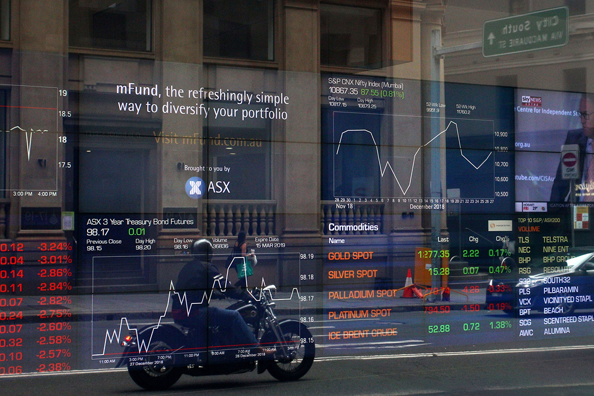 Photo: A motorcyclist is reflected in a window as electronic boards display stock information at the Australian Securities Exchange in Sydney on January 11, 2019. Photographer: Lisa Maree Williams/Bloomberg