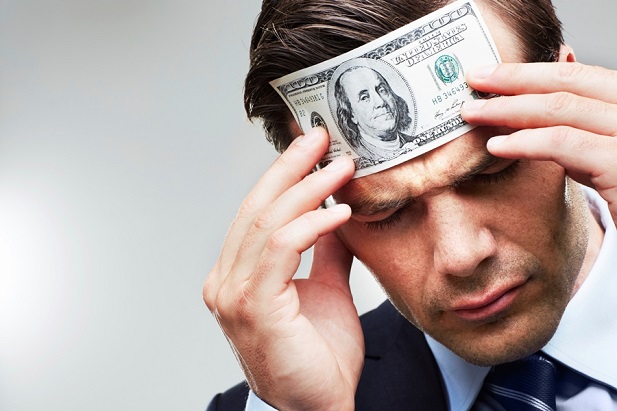Stock image: man with money pressed to his forehead. (Photo: Getty)
