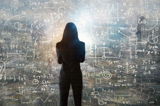 woman standing in front of chalkboard filled with calculations