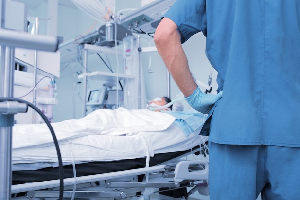 Stock photo: Nurse standing by patient in hospital bed