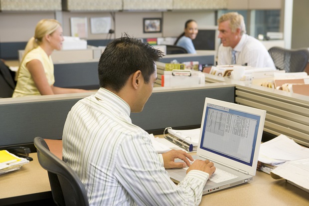 Stock photo: Man at workstation in office with others