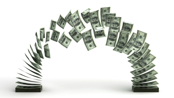 Stock image: Dollars flying between two stacks of dollars. (Photo: Shutterstock)